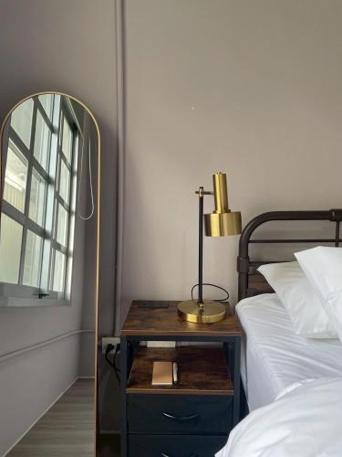 a lamp on a night stand next to a bed at 未半文旅 in Yilan City