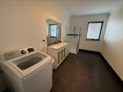 a bathroom with a washing machine and a sink at Karma on Compass in Edithburgh