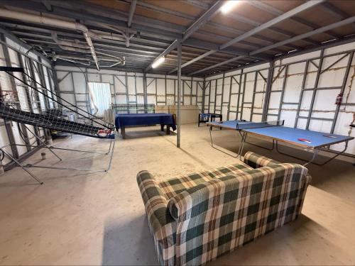 a room with two ping pong tables and a couch at Karma on Compass in Edithburgh