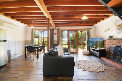 a living room with a couch and a fish tank at The Nest Rustic Lodge-Style Hideaway in Beechworth