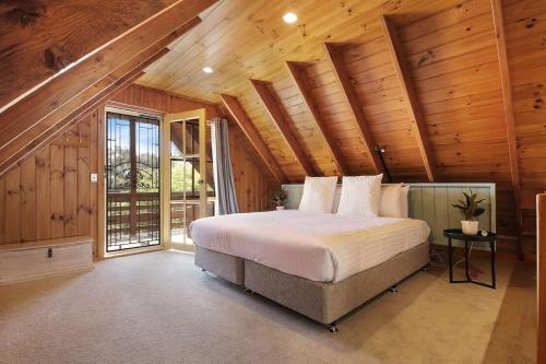 a bedroom with a bed and a wooden ceiling at The Nest Rustic Lodge-Style Hideaway in Beechworth