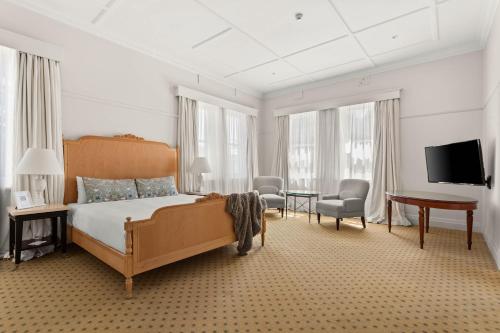 a bedroom with a bed and a desk and a tv at The Robertson Hotel in Robertson