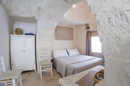 une chambre avec un lit, une table et des chaises dans l'établissement Pignarè, à Locorotondo