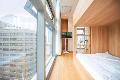 a bedroom with a bed and a large window at akastay Myeongdong in Seoul