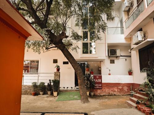 a building with a tree in front of it at SAIR Hostel, Varanasi - 100m from Assi Ghat in Varanasi
