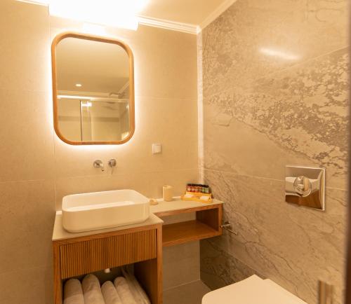 a bathroom with a sink and a mirror at Aetoma Hotel in Nafplio
