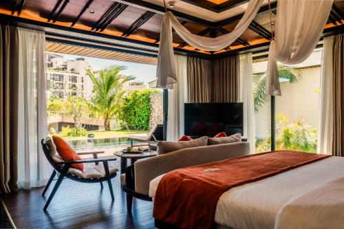 a bedroom with a king sized bed and a living room at Amiana Resort Cam Ranh in Cam Ranh