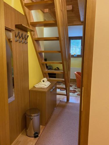 a room with a staircase with a yellow wall at Penzión - Tempo in Kremnica