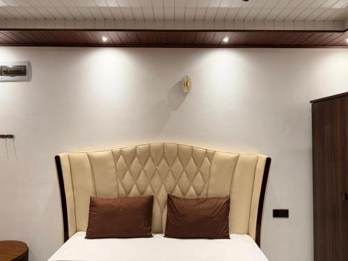 a bed with two brown pillows in a room at Millennium Hotel in Jaffna