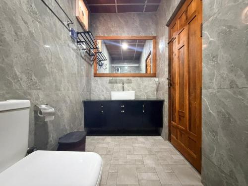 a bathroom with a toilet and a sink and a mirror at Millennium Hotel in Jaffna