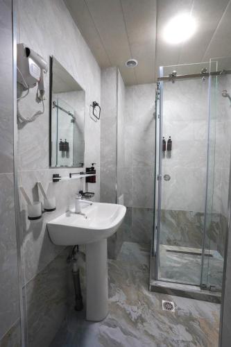 ein Badezimmer mit Waschbecken und Dusche in der Unterkunft Florence Hotel in Jizzax