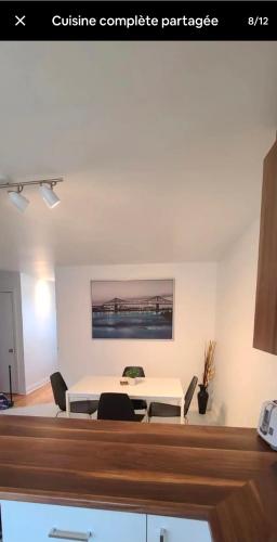 a dining room with a white table and chairs at Private rooms in shared appartment in Montréal
