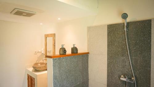 a bathroom with a shower and a sink at Puri Rinjani Bungalows in Kuta Lombok