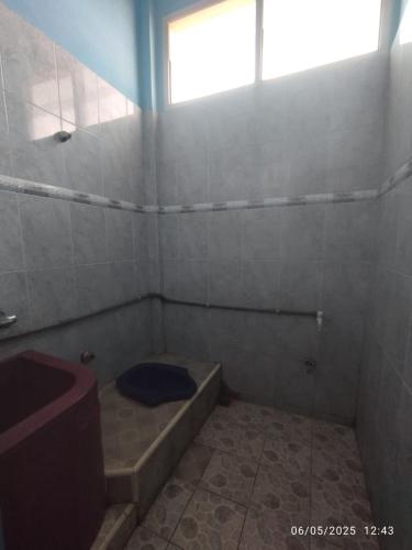 a bathroom with a tub and a toilet and a window at Penginapan Verlo in Payakumbuh