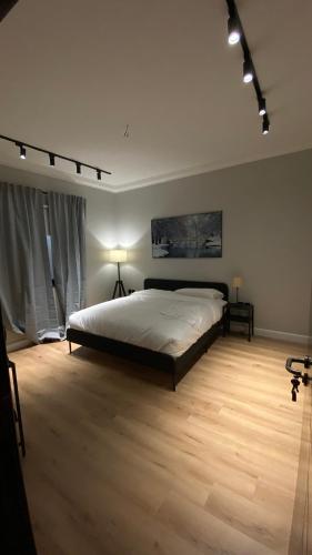 a bedroom with a large bed and a wooden floor at Cozy privet unit شقة وحيدة وهادئة in Riyadh