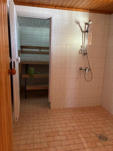 a bathroom with a shower and a tiled floor at Arctic Lodge Hetan Kota in Enontekiö