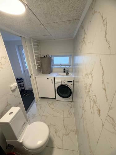 a small bathroom with a toilet and a sink at Hel hus i rolig by in Birkelse