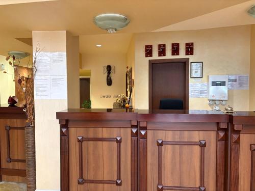 a bar with wooden cabinets in a room at Hotel OTDIH in Kavarna