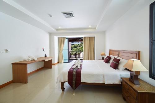 a bedroom with a large bed and a window at Surin Sabai Residence near Surin Beach in Surin Beach