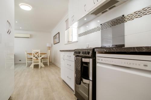 a kitchen with white cabinets and a stove top oven at Bayview Motel in Esperance
