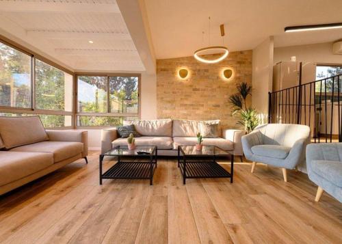 a living room with a couch and a table at אחוזת נופש ביער -ווילה עם בריכת ספא וזרמי עיסוי in Ma'alot Tarshiha