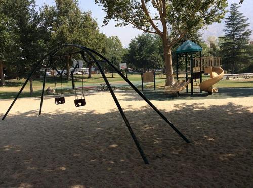 a playground with a slide and a swing set at Kern Riverfront Lodge in Kernville