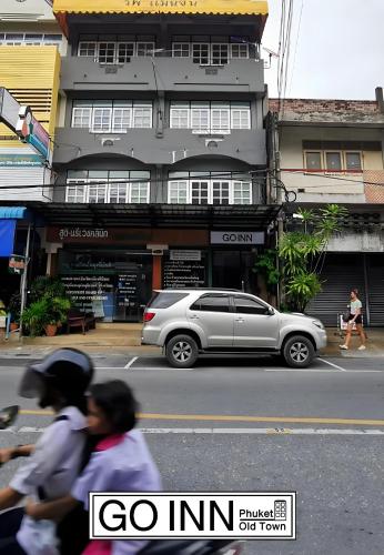 a silver car parked in front of a building at xx GO INN Phuket old Town in Ban Lo Long
