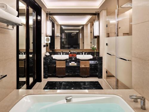 a bathroom with three sinks and a bath tub at Vignette Collection Palm Springs Hotel Chengdu by IHG in Chengdu