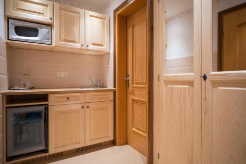 a kitchen with wooden cabinets and a microwave at Gasthaus Posch in Miesbach