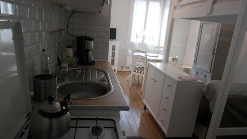 une cuisine avec un évier et un plan de travail dans l'établissement Les Althéas, à Villers-sur-Mer