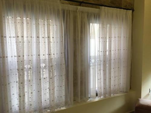 a window with white curtains in a room at Asamina Boutique Hotel in Soûr