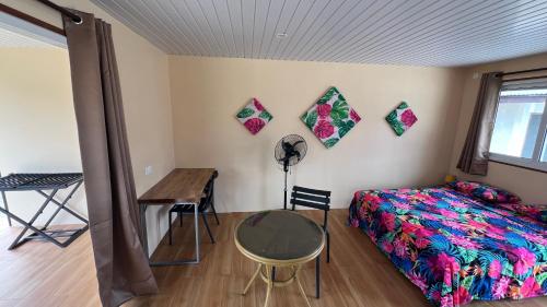 a bedroom with a bed and a table and a desk at Hiti Village G3 in Tikehau