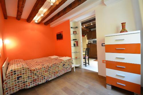 ein Schlafzimmer mit einer orangefarbenen Wand und einem Bett in der Unterkunft BARBERA-Biennale in Venedig
