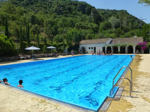 a large blue swimming pool with people in it at Casa Rural El Aljibe in Benamahoma