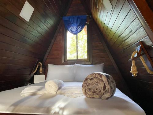 a bed in a small room with a window at Sol y Luna Chalet with volcano view and Jacuzzi in Fortuna