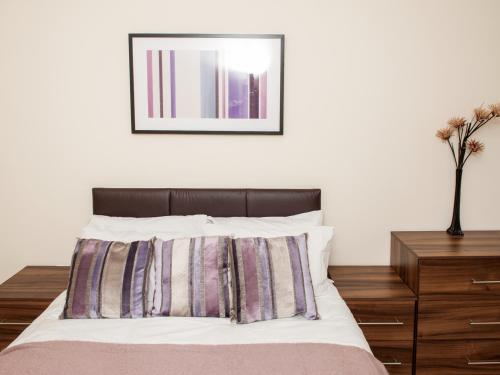 a bedroom with a bed with a picture on the wall at PSF Panorama Apartments in Ashford