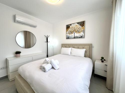 a bedroom with a white bed with towels on it at STAY Sun Line Apartment in Nicosia