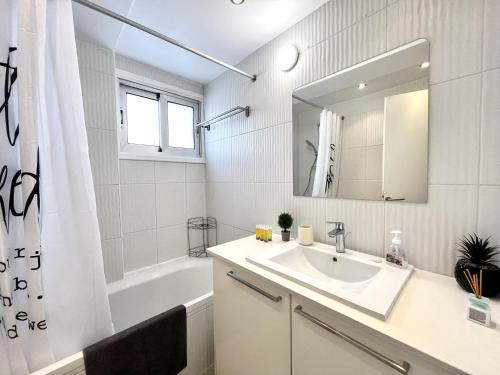 a bathroom with a sink and a tub and a mirror at STAY Sun Line Apartment in Nicosia