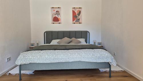 a bed in a bedroom with two pictures on the wall at CasaFranken in Wiesenthau