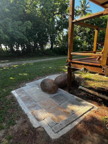 a stone patio with two rocks and a building at Reef Coast Cottage Absolute Beachfront in Mission Beach