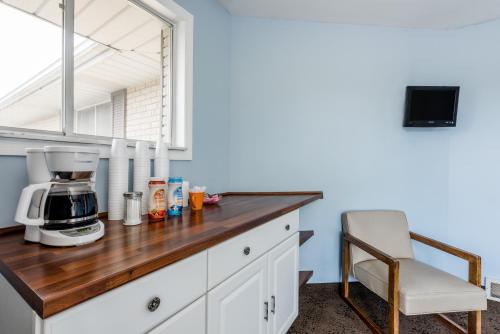 encimera de cocina con cafetera y silla en Knights Inn Pine Grove, en Pine Grove