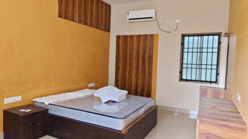 a bedroom with a bed and a window at Le DPS Viste in Rāyampālaiyam