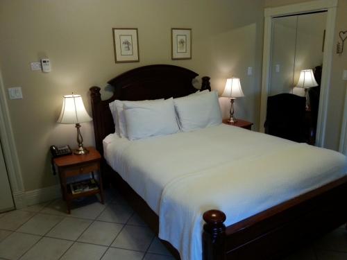 a bedroom with a large bed with two lamps at Chipman Hill Suites - Union Street in Saint John