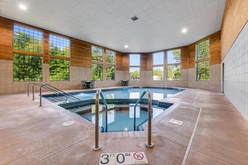 a large indoor swimming pool in a building with windows at Comfort Inn & Suites Weston - Wausau in Weston