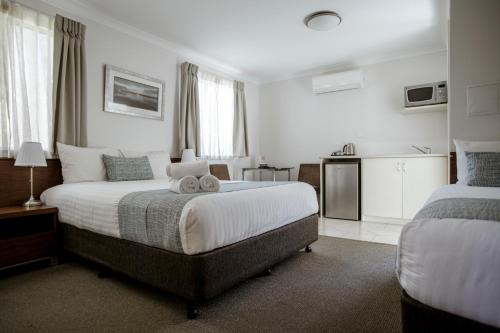 a hotel room with two beds and a kitchen at Kalbarri Edge Resort in Kalbarri