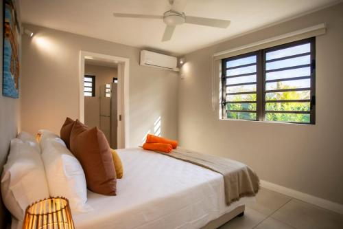 a bedroom with a white bed and a window at Salty Sands Studio in Rivière Noire