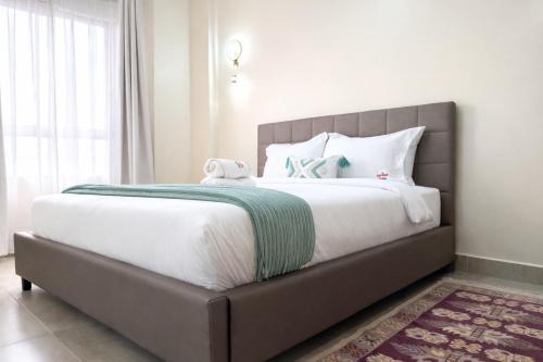 a bedroom with a large bed with white sheets at Shawmut Executive Suites With Heated Pool, GYM, Secure Parking, Full Power Backup in Nakuru