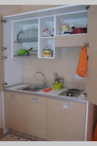 a kitchen with white cabinets and a sink at Le Casette in Matera