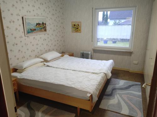 a bedroom with a bed and a window at FEWO Stephan Grünewald in Gunzenhausen