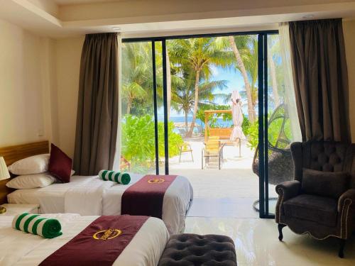 a hotel room with two beds and a balcony at Chak’z 1964 Beach in Dharavandhoo